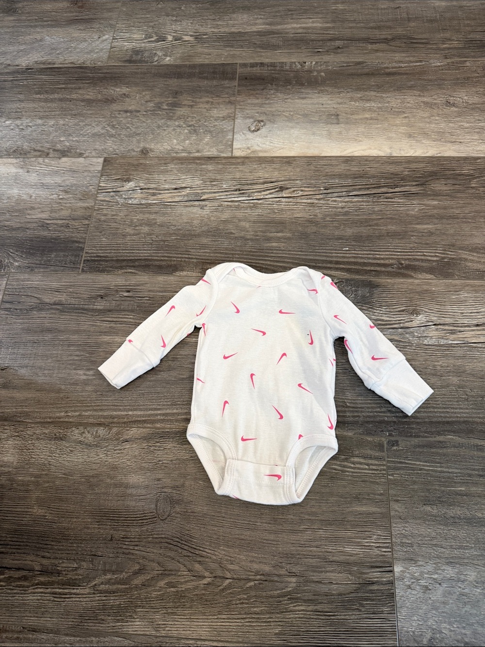 Nike White Long-Sleeve Baby Bodysuit with Pink Swoosh Print